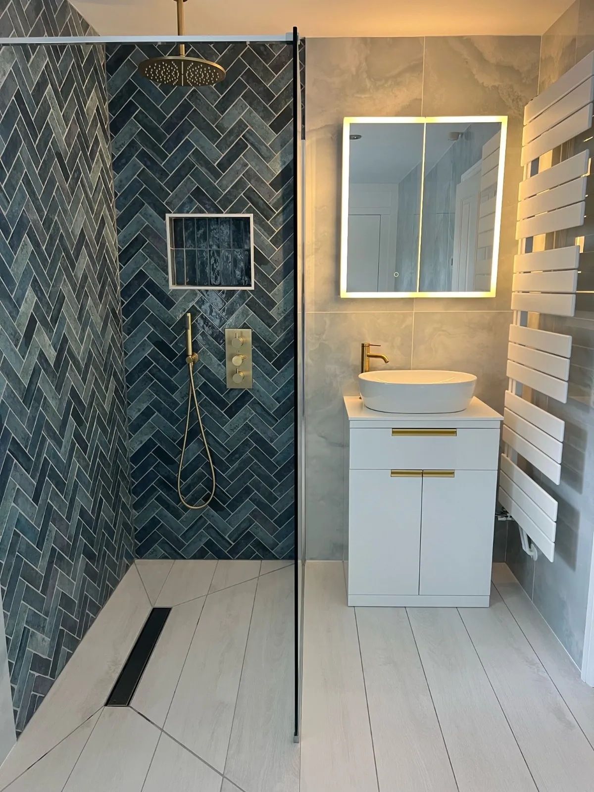 A bathroom with a walk in shower next to a sink.
